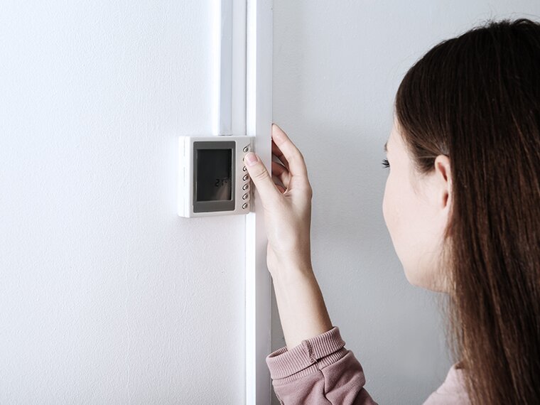 Blick über die Schulter einer Frau beim Bedienen des HLK-Reglers